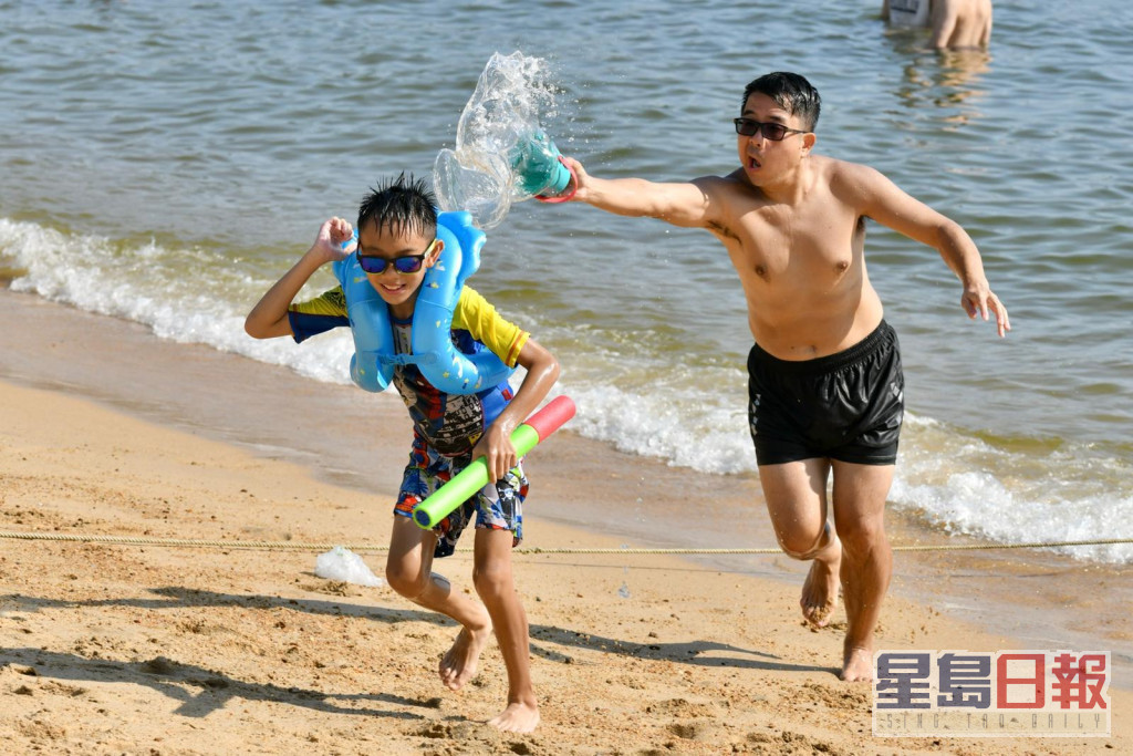 家長與小朋友在沙灘玩水消暑。
