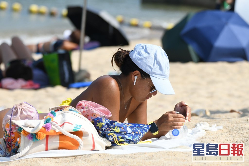 天氣持續酷熱，市民到海邊日光浴。資料圖片
