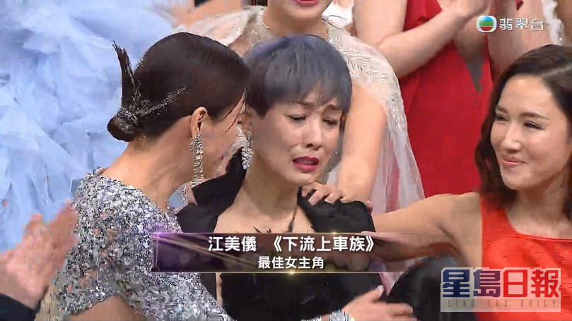 得奖一刻，江美仪获相识多年的陈炜（左）揽揽祝贺。