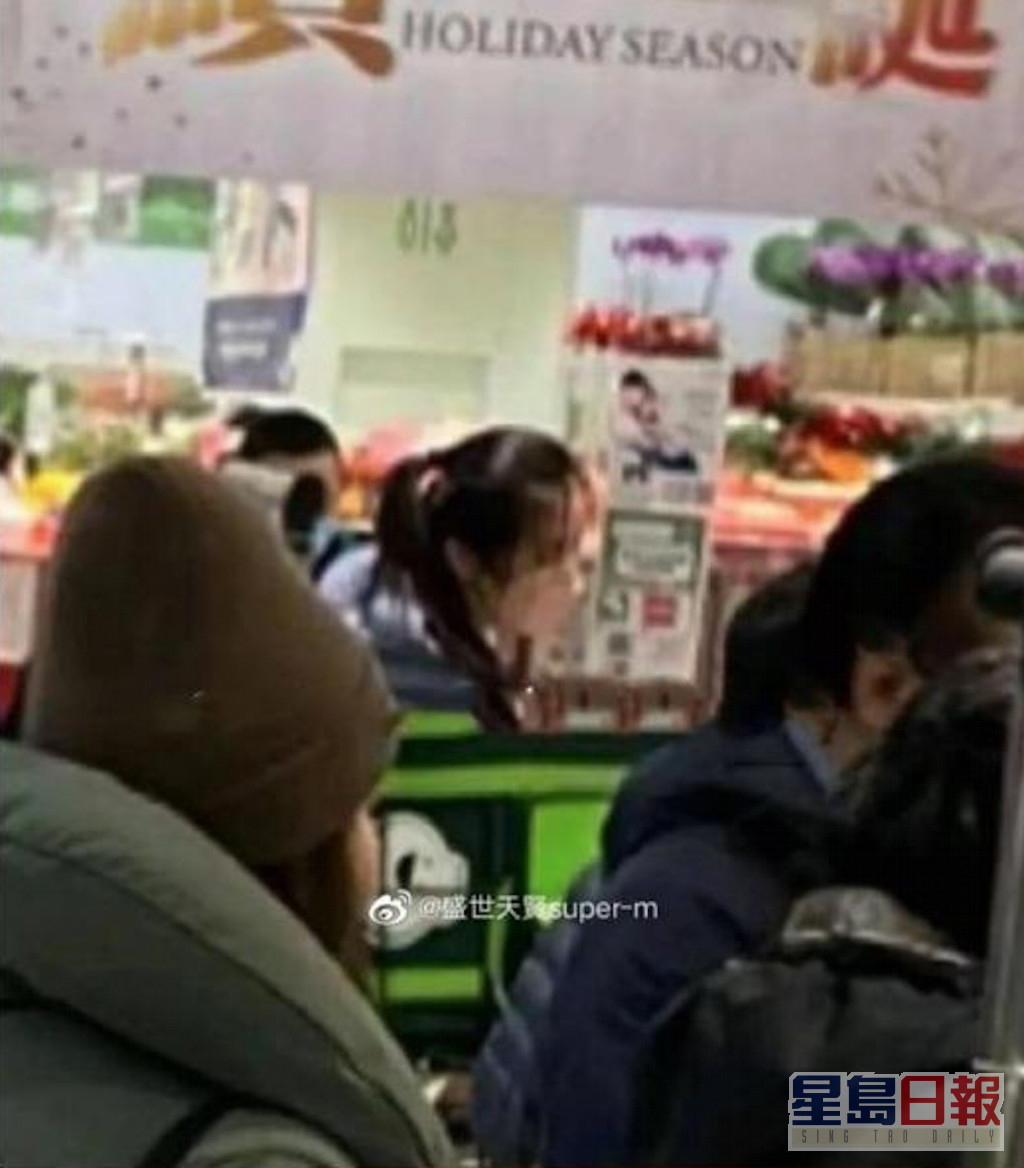 王祖賢身穿藍色的羽絨外套，在超市的人群中排隊等結帳。