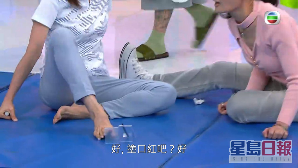 姚瑩瑩用腳同何芷姍化妝。