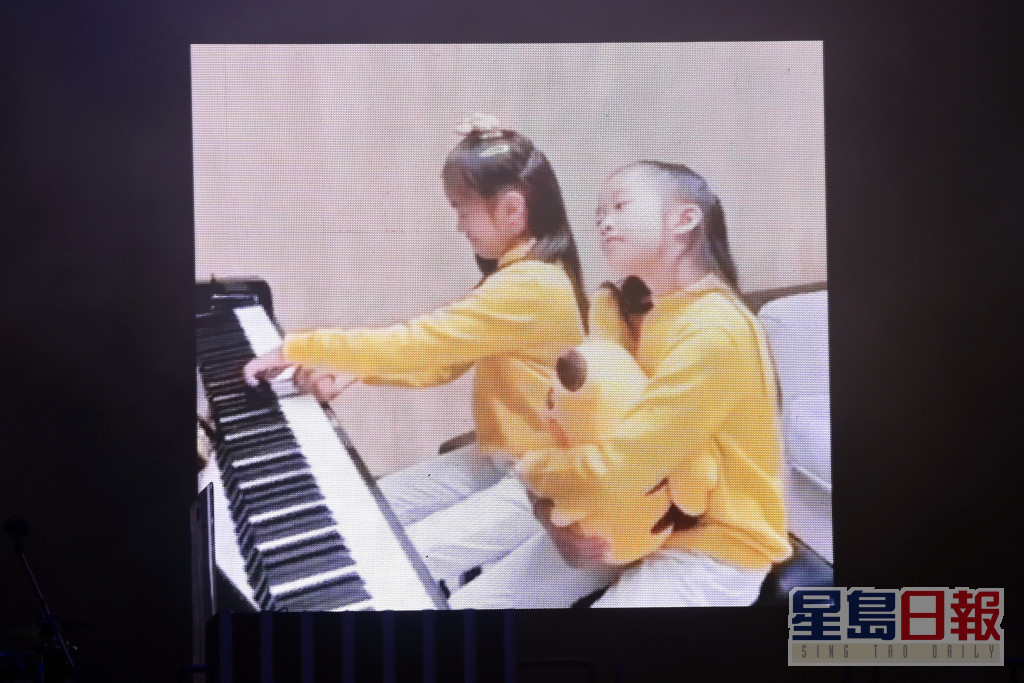 東東返後台換衫時，螢幕上播放佢兩位寶貝女自彈自唱《心有獨鍾》。