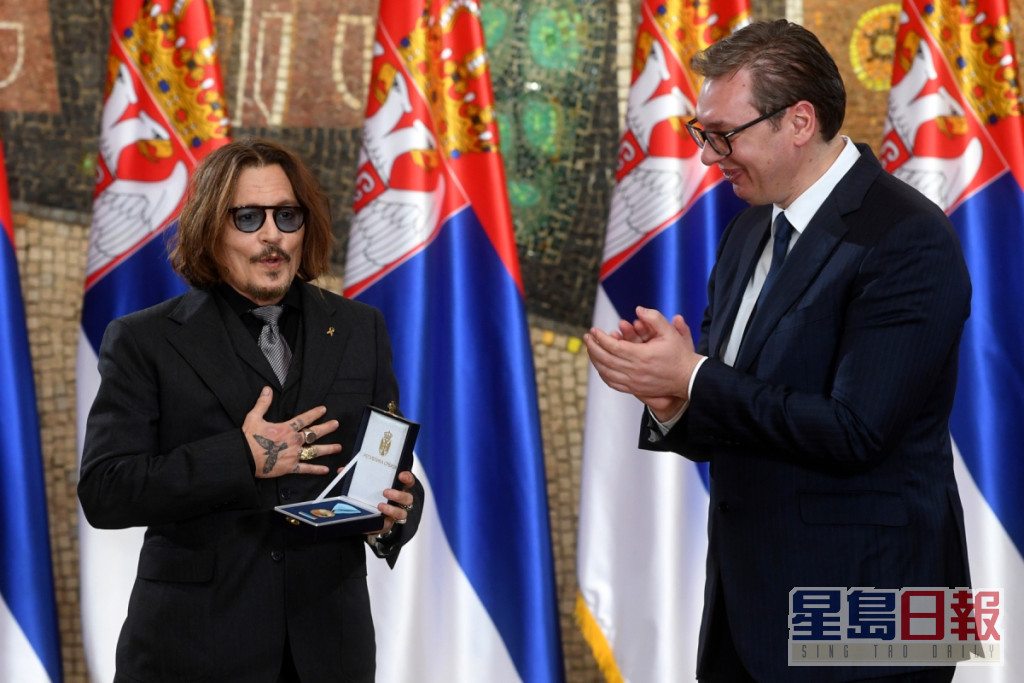 尊尼昨現身塞爾維亞，獲總統武契奇（右）頒發金勳章表揚。