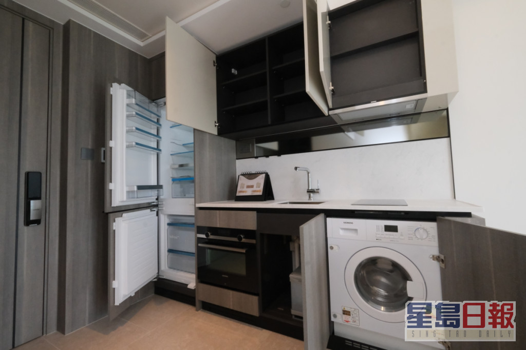 开放式厨房的电器收纳于米色木纹版面的厨柜内。（12楼B室）