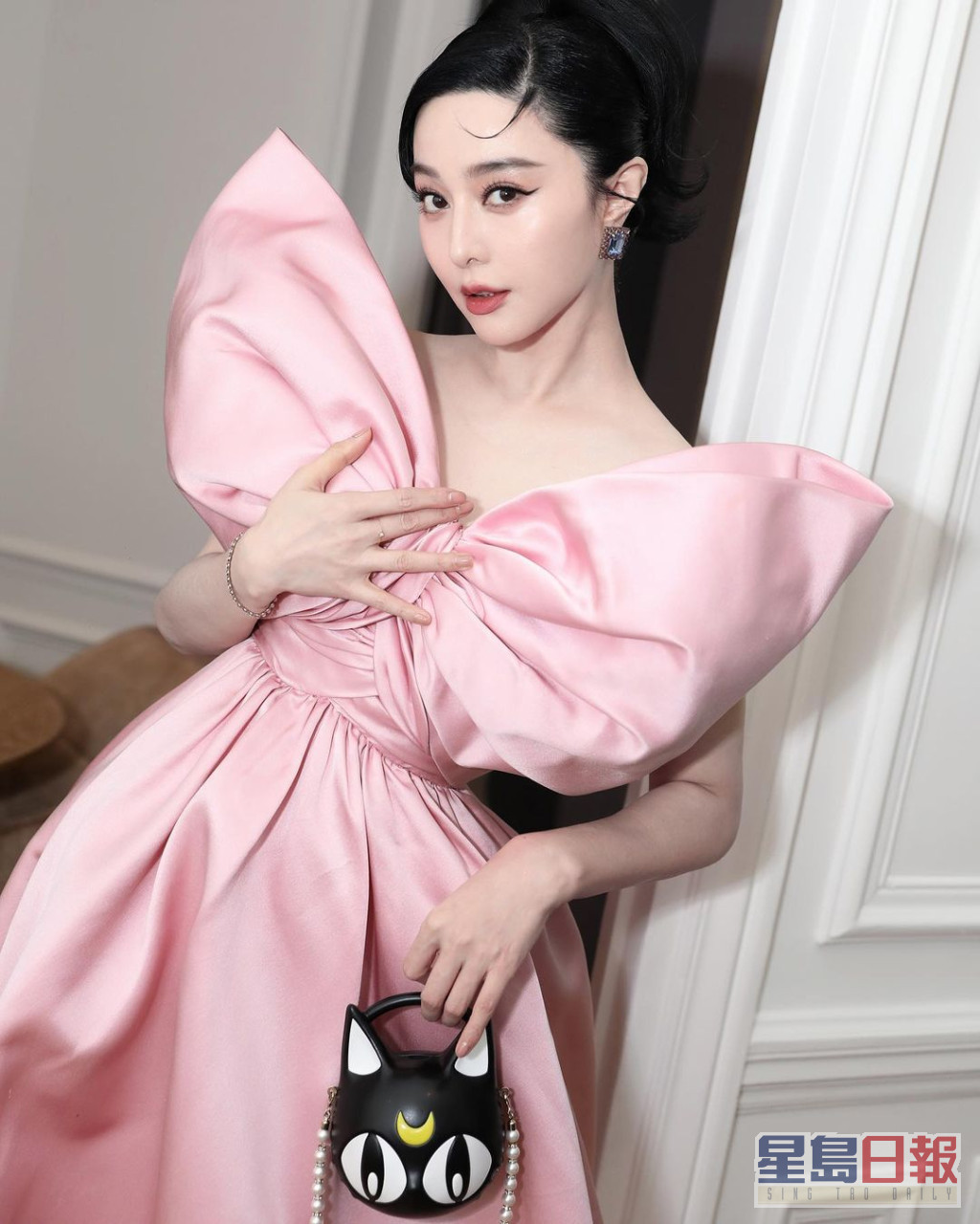 以意大利時尚品牌Giambattista Valli的粉紅色蝴蝶結晚裝，加上Jimmy Choo聯乘《美少女戰士》的露娜手袋現身，充滿少女心。