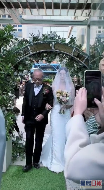 新娘子Vanilla跷实爸爸进入婚礼现场。