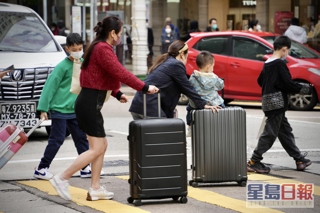 有遊客推着行李篋在廣東道一帶逛商店。蘇正謙攝