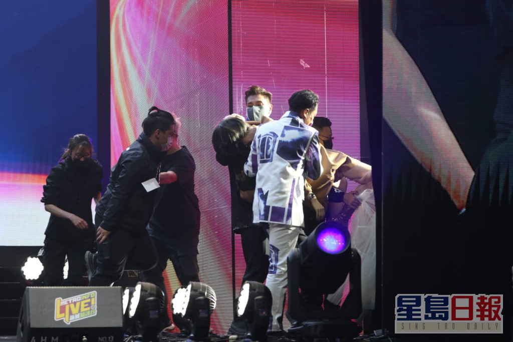 吴浩康和陈展鹏帮手将晕倒嘅锺雨璇抬返后台。