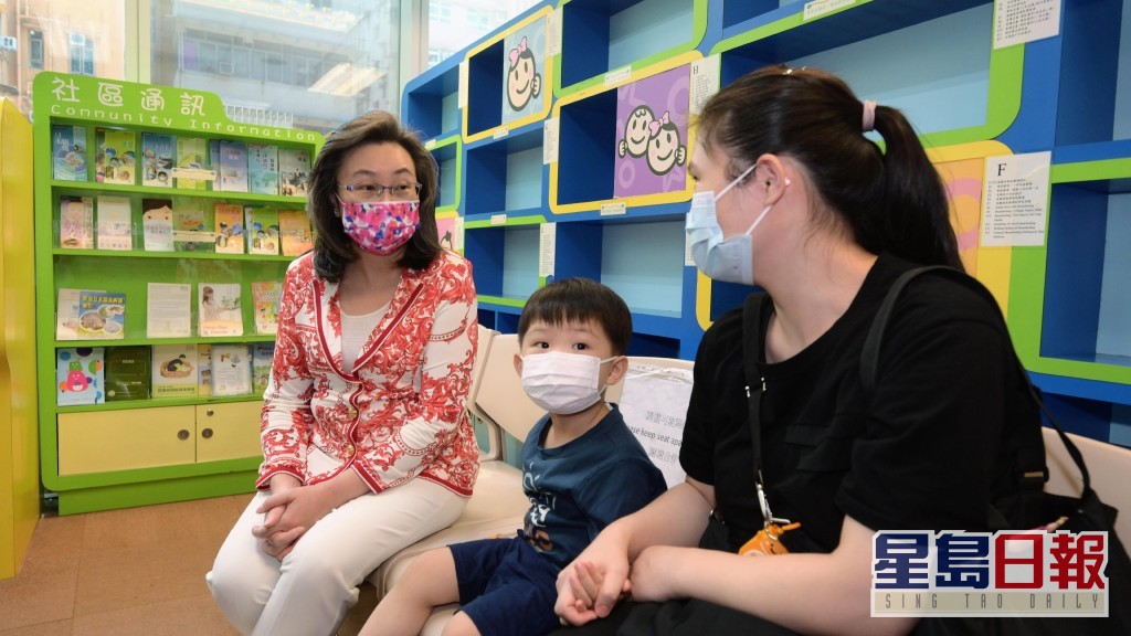 杨何蓓茵（左一）与一名幼童的家长倾谈，了解她对幼童接种新冠疫苗的意见。政府图片