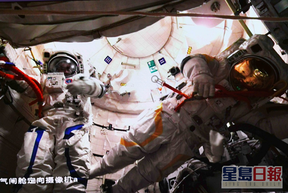 陈冬（左）、蔡旭哲结束出舱任务返回问天实验舱的画面。
