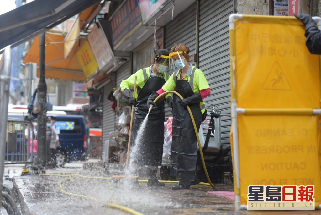 清潔工以強力水槍洗街。