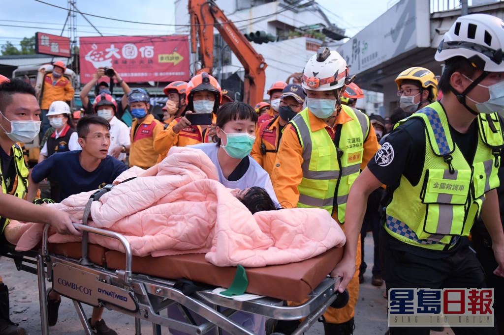 搜救人員在瓦礫中救出傷者。AP
