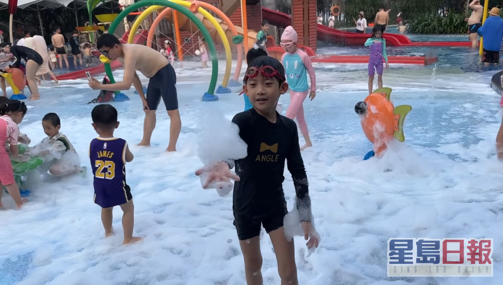 7岁细仔JT在酒店泳池玩泡泡。