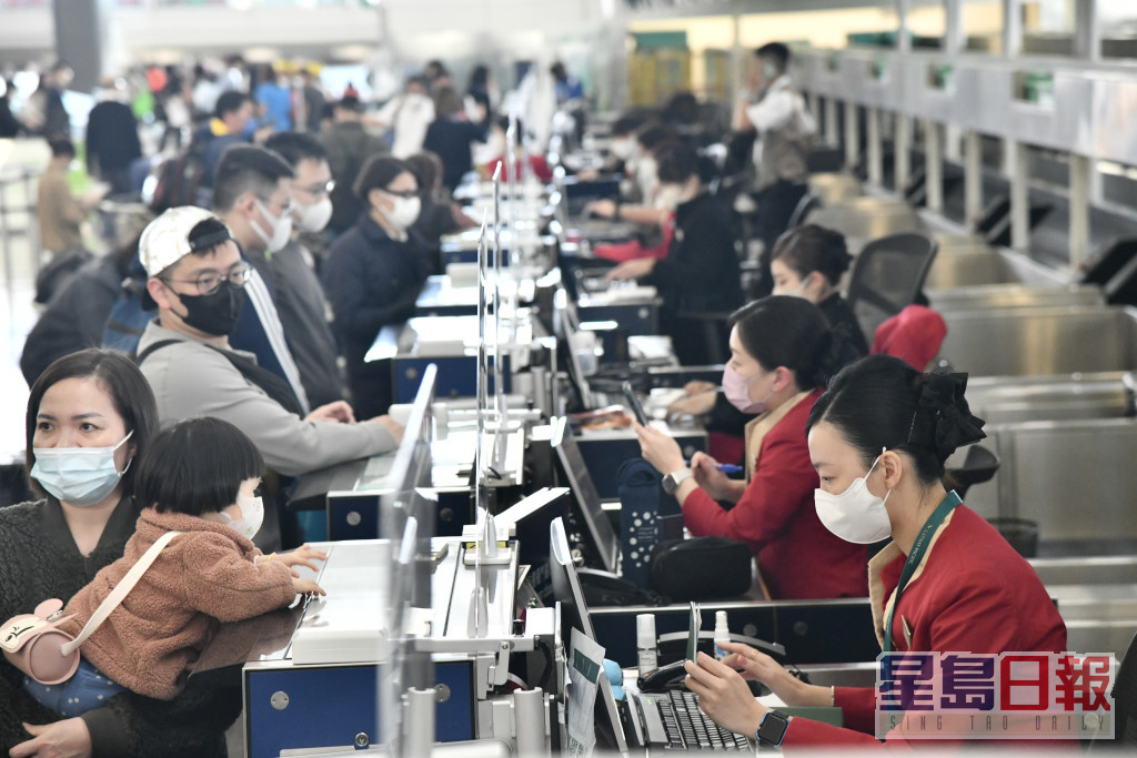 大批乘客在機場出境大堂辦理登機手續。盧江球攝