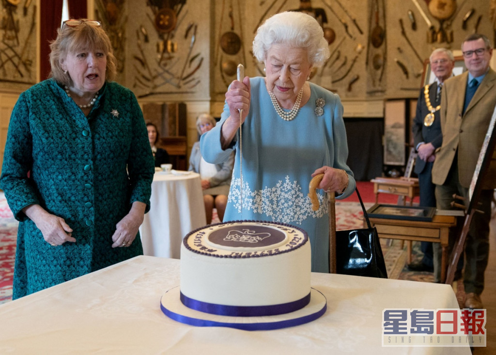 英女皇切了居民为她烤焗的蛋糕。REUTERS