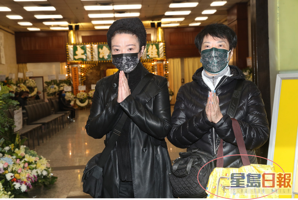 4月3号，刘雅丽及妈妈包晓华喺灵堂门口接受访问，当时后者手持载住帛金嘅黄色布袋周围走。