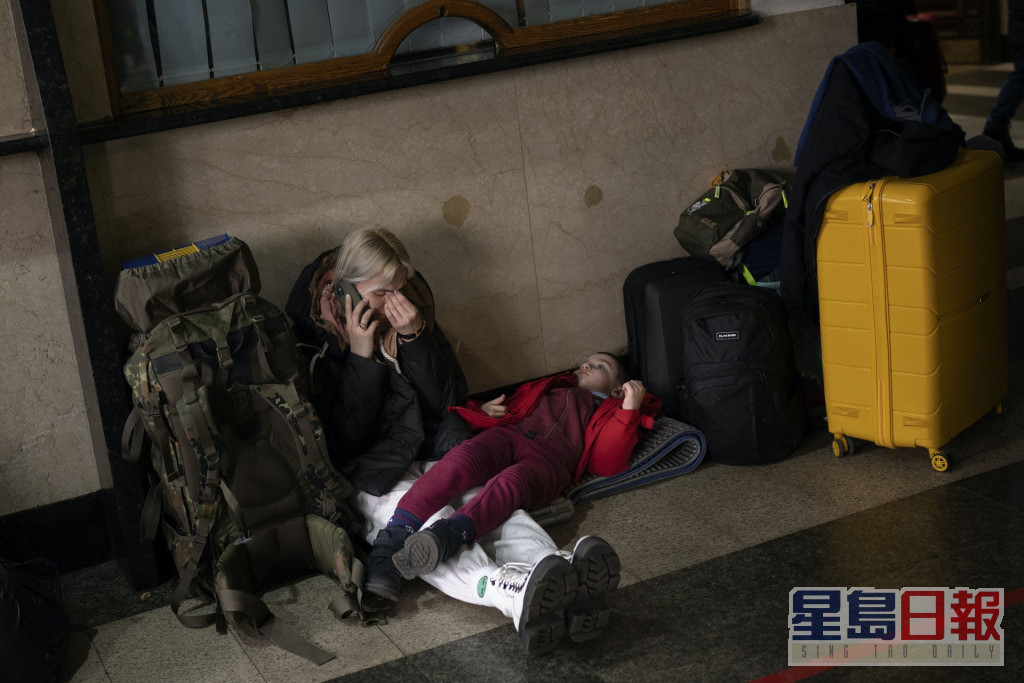 一對母女坐在車站地上，等待乘搭離開基輔的火車。AP