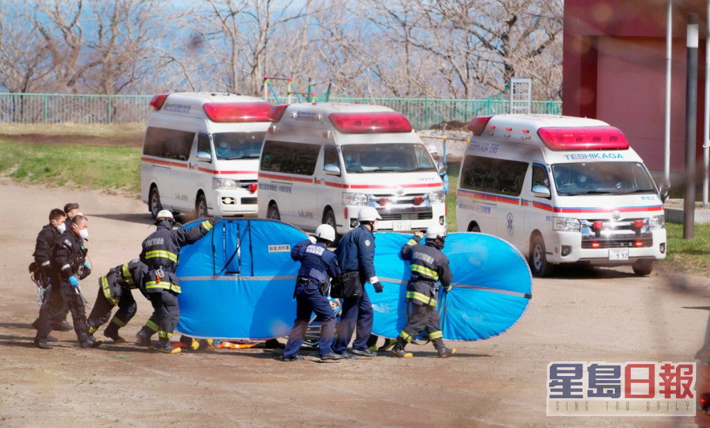 救护员用担架床将伤者送院抢救。AP