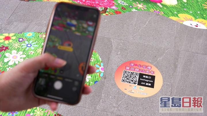 市民以手机扫描二维码后，可以特色滤镜在现场打卡。
