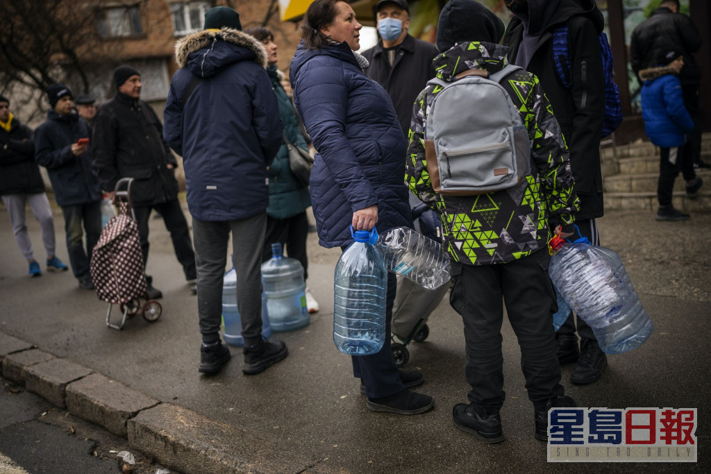 基輔市民帶同膠樽等待入店內買水。AP