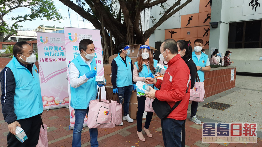香港义工联盟向每位接种疫苗的市民派赠内含5盒快测套装的「抗疫爱心包」。