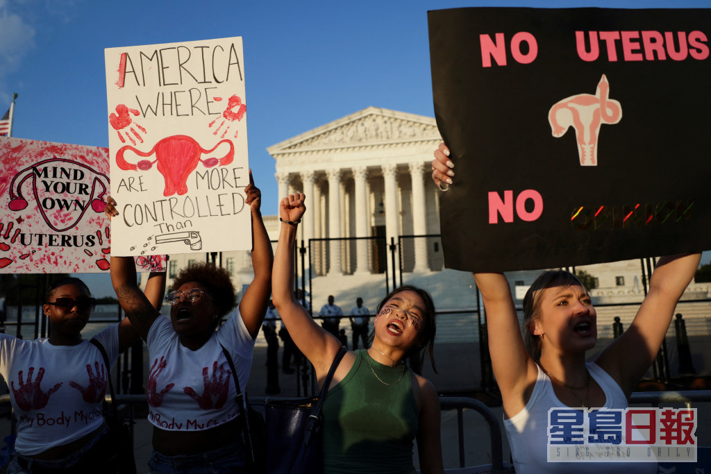 有人举起横额和标语牌抗议禁堕胎。REUTERS