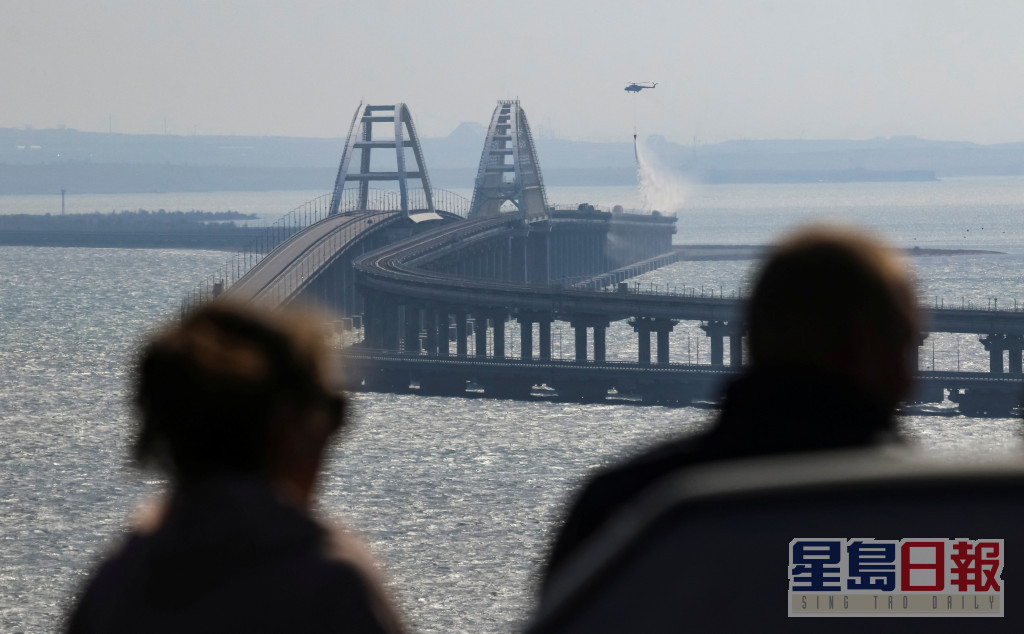 大橋上空大火竄起數米高，多節車廂瀰漫濃煙，橋面崩塌掉入海中。。路透社圖片