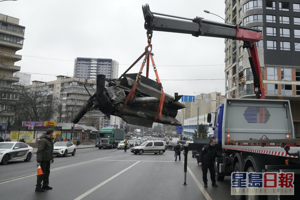 在首都基辅，工人吊走受袭后遗下的火箭弹碎片。AP