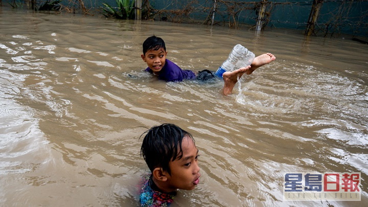 尼格在部分地区引发水灾，儿童在水中畅泳。路透社图片