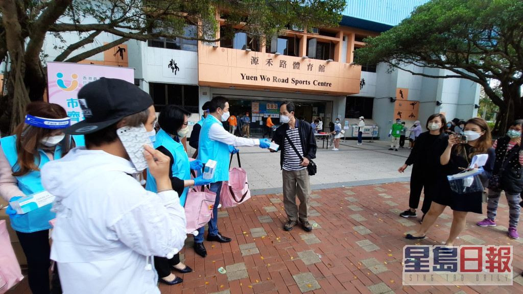 香港义工联盟向每位接种疫苗的市民派赠内含5盒快测套装的「抗疫爱心包」。
