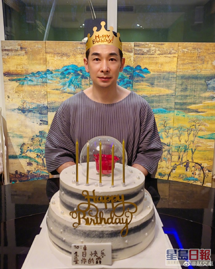 赵文卓戴上皇冠坐在蛋糕前，好鬼正经咁影相。
