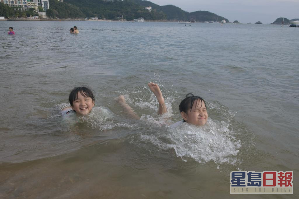 浅水湾沙滩人声鼎沸，市民戏水消暑。