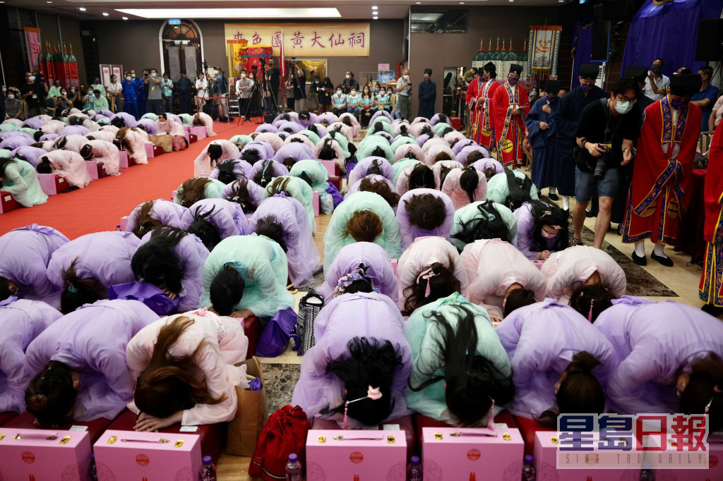 近200名穿着華服的女性向黃大仙像行三跪九叩禮。