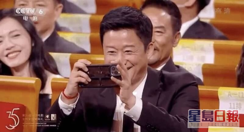 昨日（13日）吴京现身电影金鸡奖，一见刘德华上台即化身小粉丝在台下拿出手机狂拍，被发现非手持其代言的国产品牌中兴手机，而是美国品牌苹果手机。