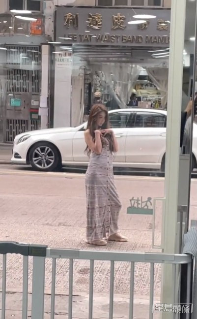 穿連身長裙的薛凱琪在馬路上擺Pose拍照。
