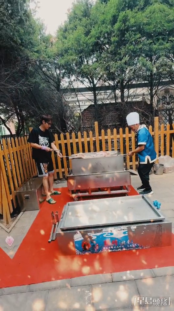 張丹峰一身黑Tee波褲街坊Look,踢住拖鞋與男友人在花園碳燒全羊。