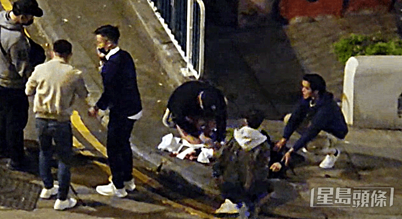 事主倒臥地上，途人協助救人及報警。