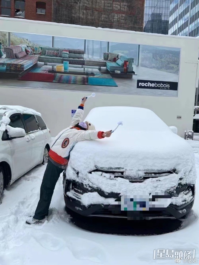 恬妞調皮地躺在鋪滿厚雪的車面拍照。