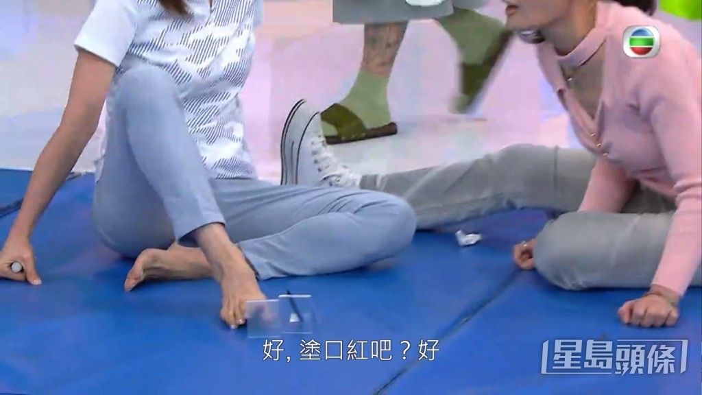 姚瑩瑩用腳同何芷姍化妝。