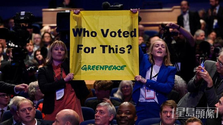 有綠色和平成員在保守黨年會上舉起標語，抗議卓慧思內閣不重視環保議題。路透社圖片