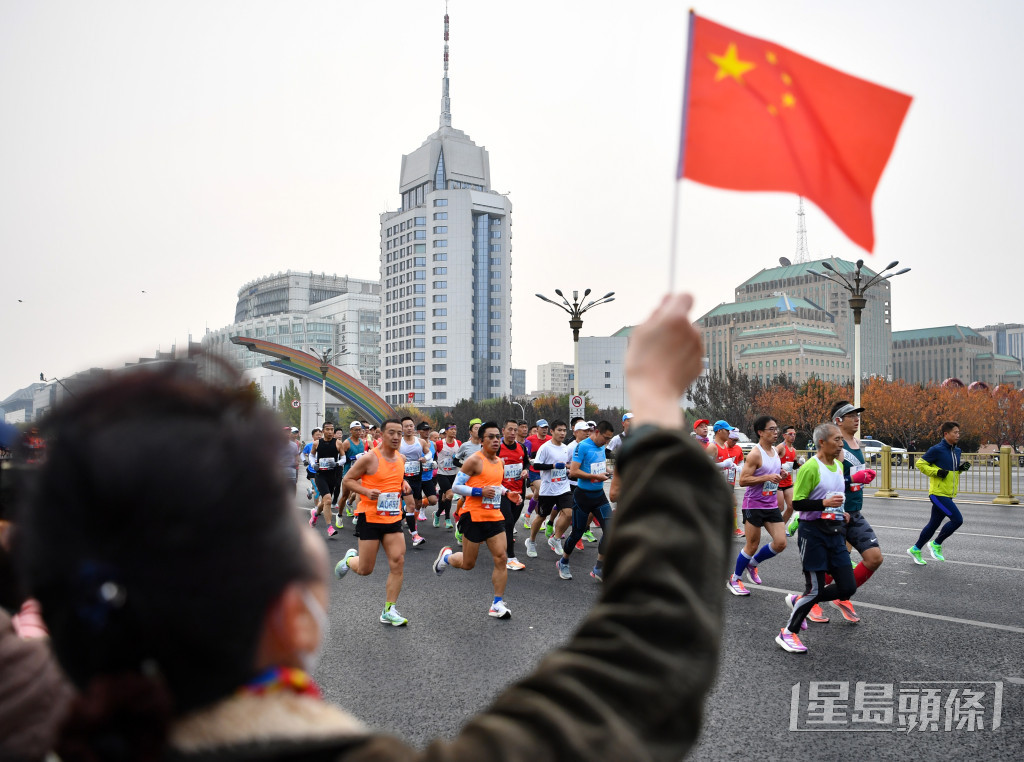 有途人為選手們打氣。新華社