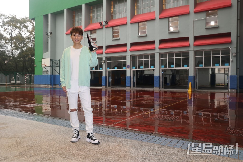 拿着奖项在校门前拍照，吉吉坦言坚持追梦终于得到点回报。
