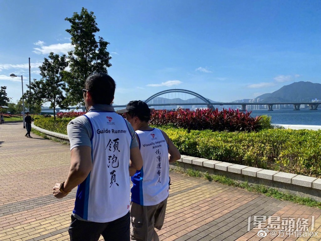 方中信帶領着視障運動員跑步。