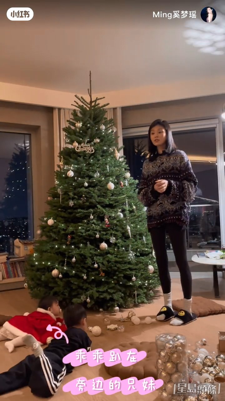 一對仔女旁觀媽咪裝飾聖誕樹。