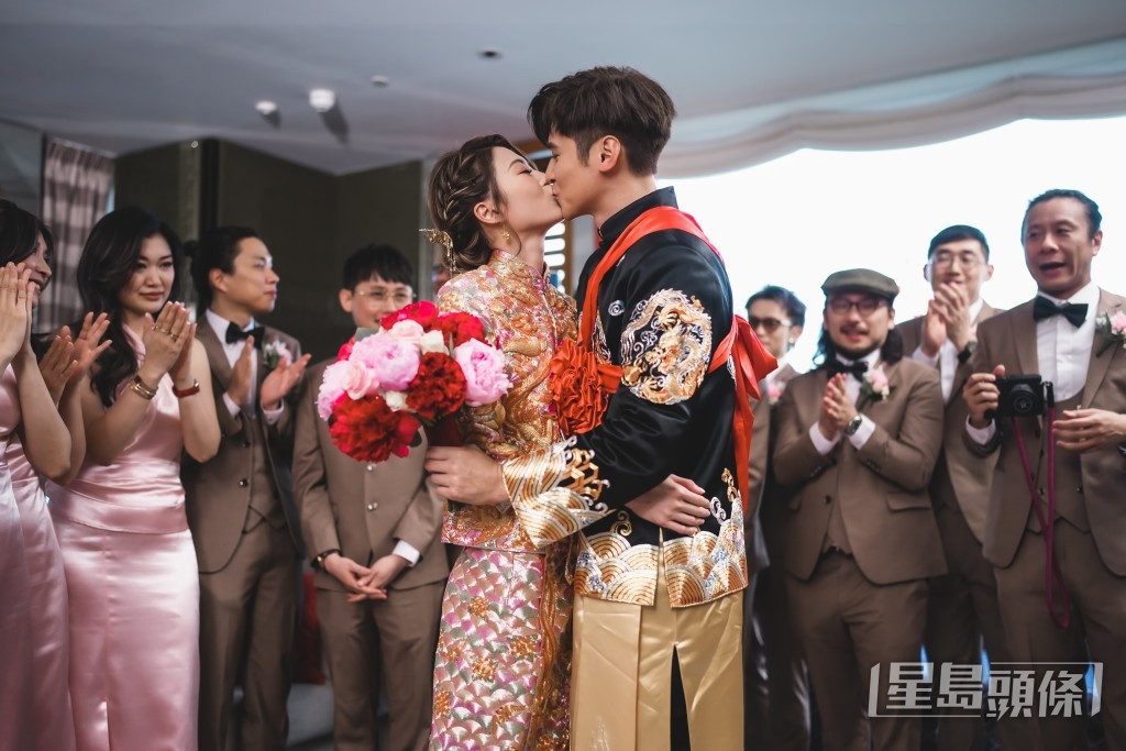 在兄弟姊妹团怂恿下，一对新人情深一吻。
