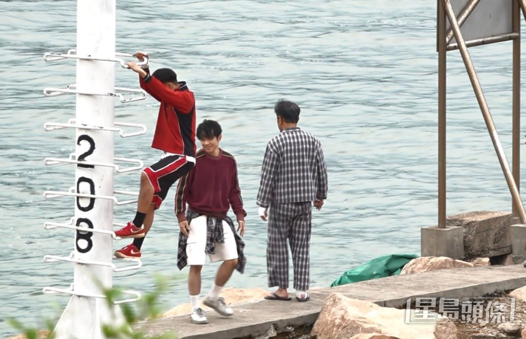 三位百厌仔见闷闷哋大胆爬上海边的一个灯塔影相打卡。