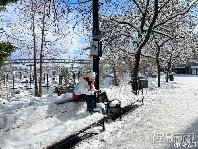 頭戴貓耳造型冷貓的恬妞在雪地留倩影。