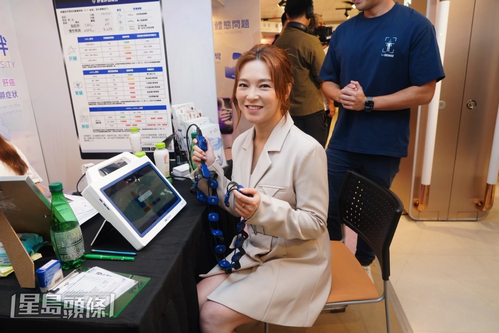 歐倩怡於展覽現場試用七款AI健康檢測儀器。