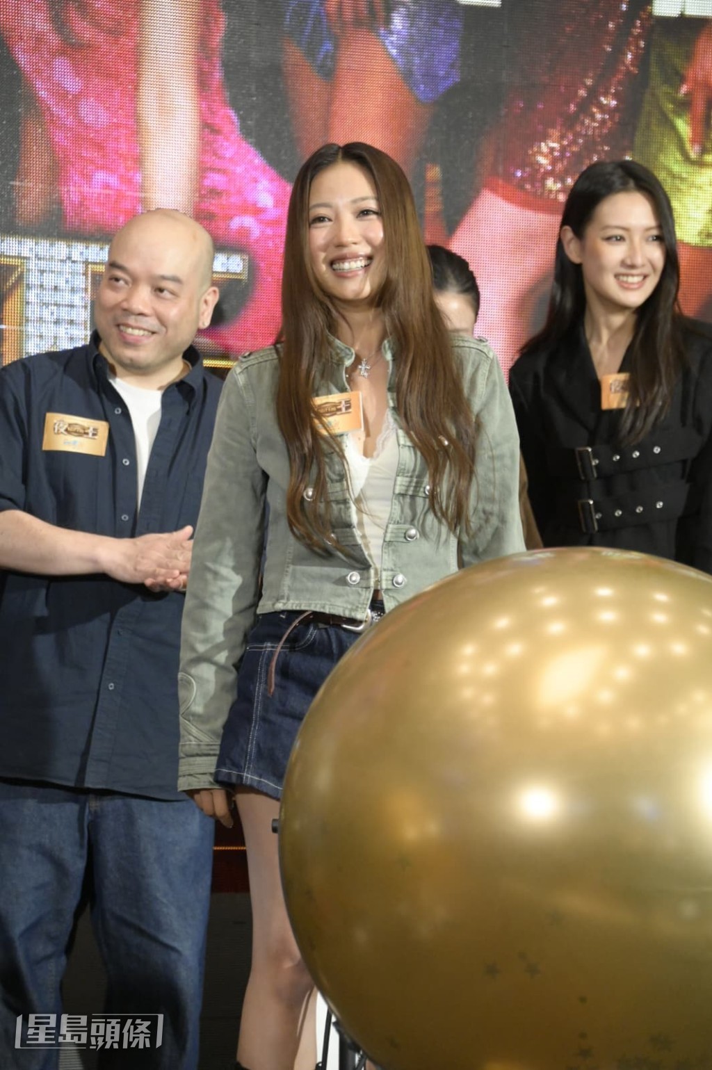 芯駖指着譚旻萱着過的黑絲或「土地」的服裝。