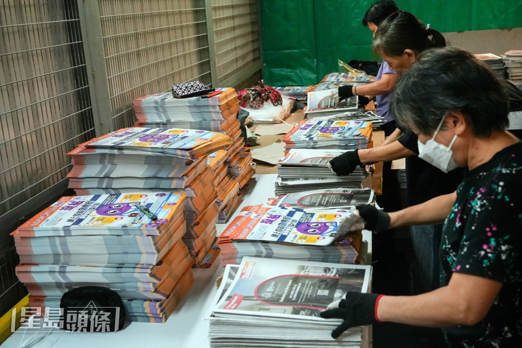 工作人員仔細分發警方防騙刊物《提紙》。吳艷玲攝